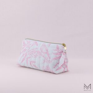 quilted cosmetic bag with zipper and custom zipper pull on a light pink background